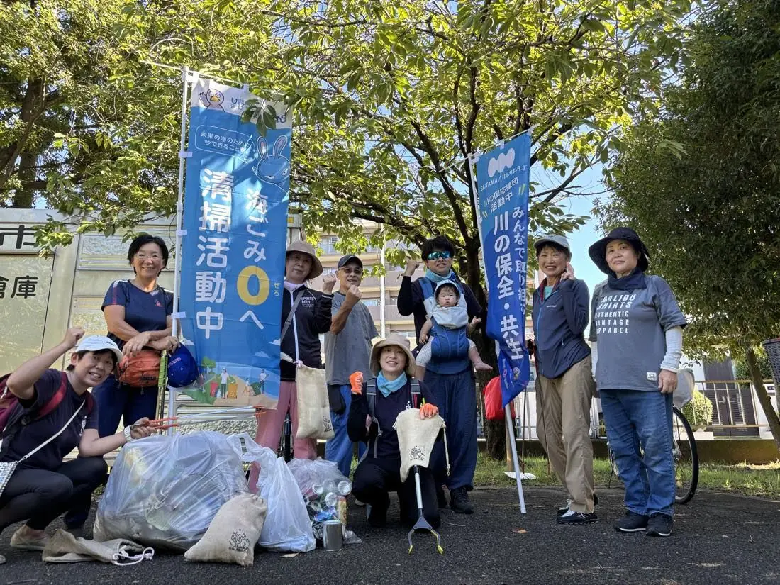 のぼりを立てて川の清掃活動に参加した地域の人々の集合写真