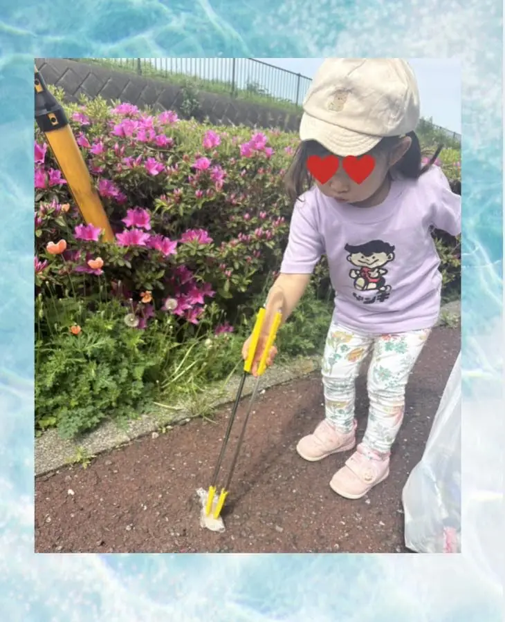 トングを持って道ばたの落ちものを拾っている子ども