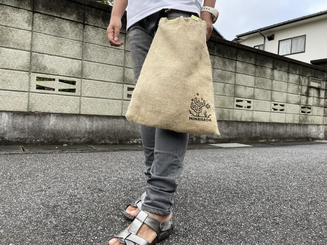 サンダルばきでポーチを肩から提げ、街の道を歩いている様子