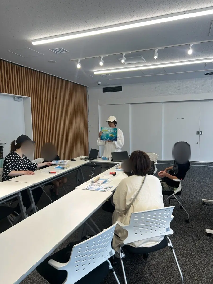 会場に机を並べ、親子が席についてワークショップに参加している様子